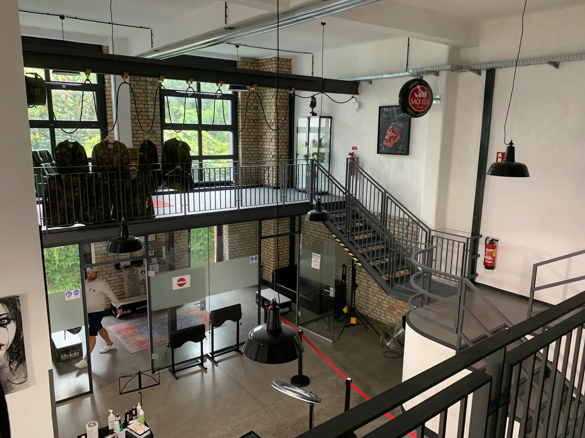 Das Studio von oben: Treppe aus Stahl, Galerie-Ebene, Backstein und Kunstwerke an den Wänden