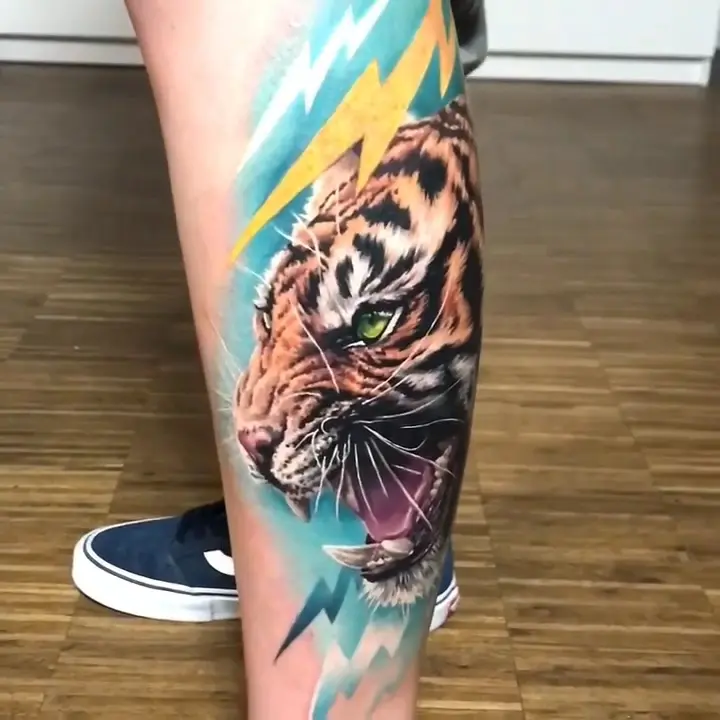 Tiger in Farbrealismus mit türkisen und gelben Blitzen auf der Wade