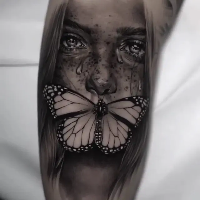 Black & Grey Realismus: Frauengesicht mit Sommersprossen und einem Schmetterling vor dem Mund